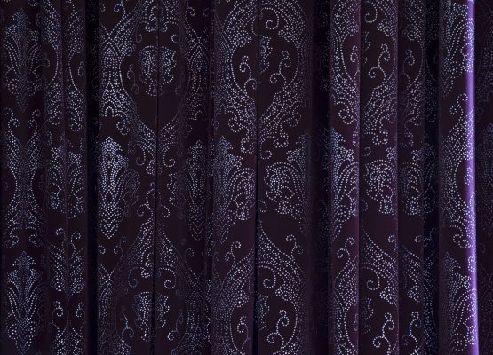 Folds of a purple curtain with sequined pattern in an old theate